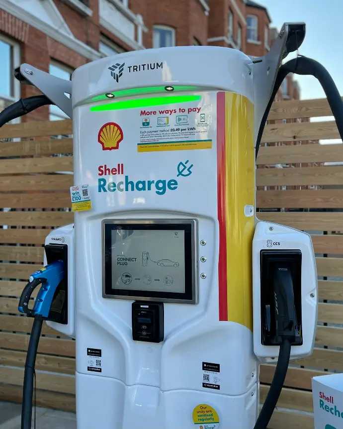 a shell gas pump with a charger attached to it